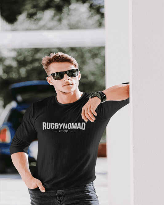 RUGBYNOMAD organic cotton heavyweight black longsleeve t shirt, rugby nomad original text logo white, male model, black sunglasses, hand in pocket, leaning on wall