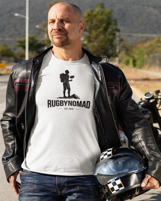 RUGBYNOMAD white organic cotton heavyweight streetwear t shirt with RUGBYNOMAD original complete logo in black est 2015 on a male model bald with a go tee, wearing a black motorcycle jacket holding a black motorcycle helmet, standing on the highway